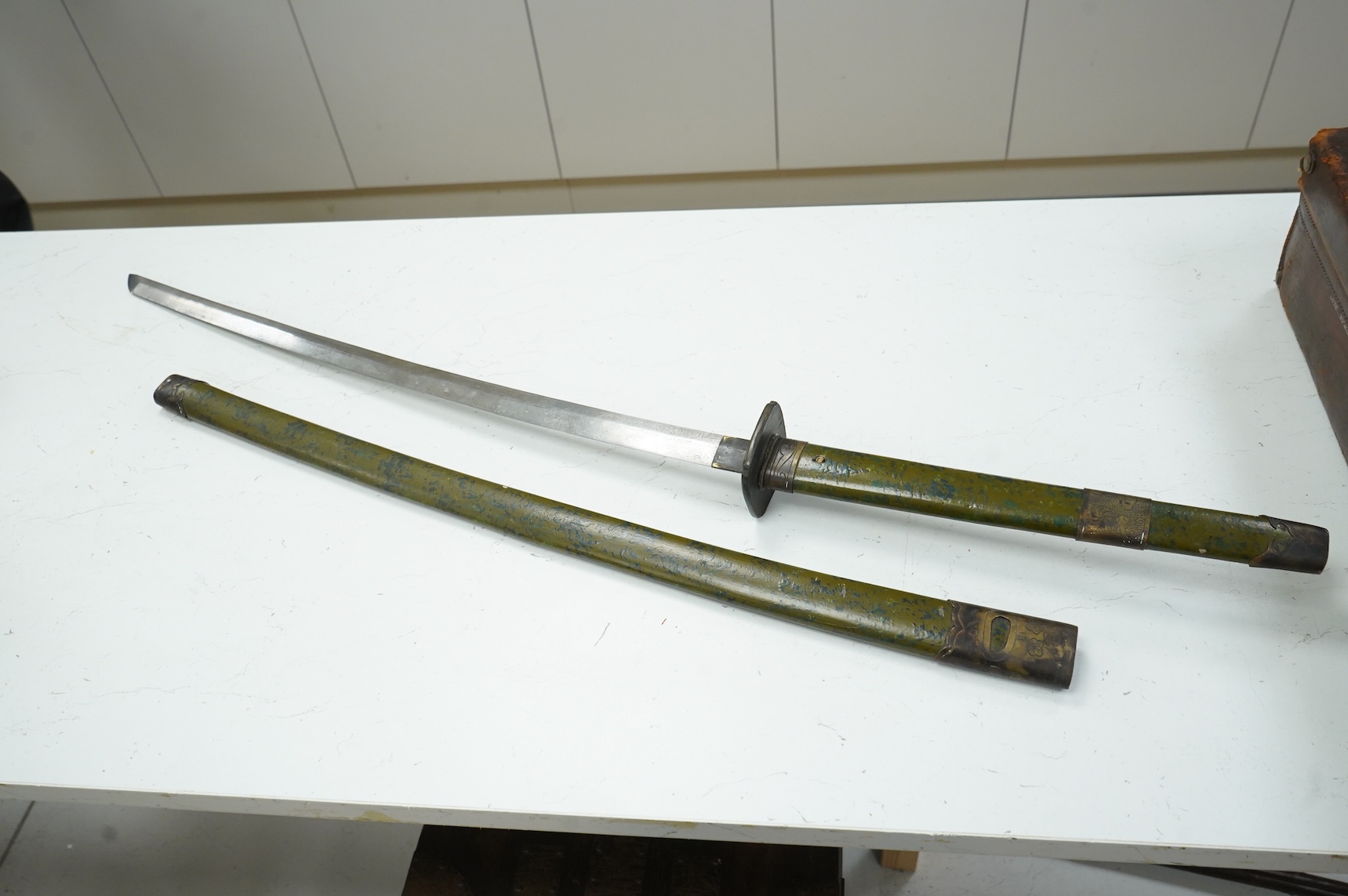 A well-made Chinese copy of a Japanese sword katana, blade etched with wood grain imitation, green painted handle, scabbard with engraved brass mounts